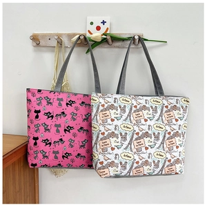 Detail of canvas tote bags featuring cat patterns and Paris Eiffel Tower illustrations