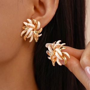 Detailed view of a 18K gold-plated metal flower stud earring with white enamel petals
