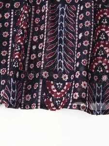 Detail of bohemian paisley print on dark blue lightweight fabric with elegant drape