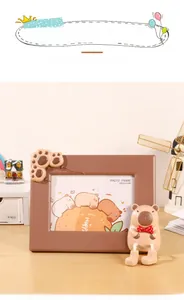 Detailansicht eines Cartoon-Fotorahmens mit niedlicher 3D-Wasserschwein-Puppe und Pfote