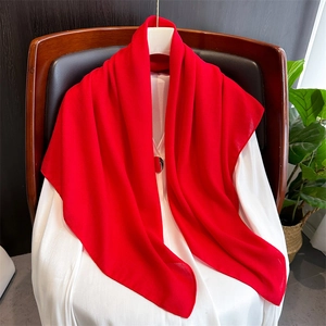 Close-up of soft red linen cotton scarf draped over a white outfit for woman decoration