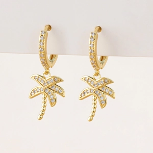 Close-up of gold palm tree earrings with micro-set white cubic zirconia stones