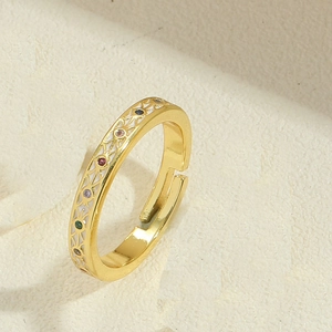 Detail of adjustable gold ring with white enamel and vibrant multi-colored gemstones
