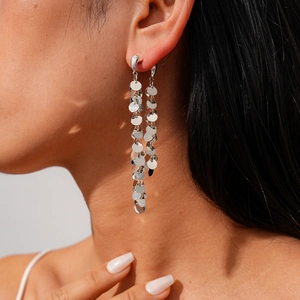 Gros plan de boucles d'oreilles à paillettes argentées avec disques et franges mobiles