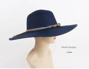 Detail of navy blue straw sun hat with decorative braided cord and metallic beads