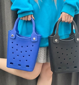 Detail of blue and black EVA waterproof tote bags with circular perforated hole patterns
