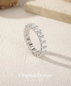 Sparkling S925 sterling silver eternity ring with round moissanite stones on stone background