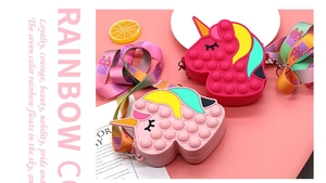 Close-up of pink silicone unicorn pop-it crossbody bags with colorful rainbow straps