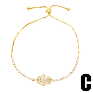 Adjustable golden Hamsa hand bracelet with white zircon and black evil eye detail