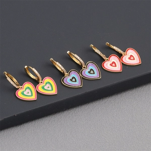 Detailed macro view of colorful enamel heart earrings with micro-set gold hoops