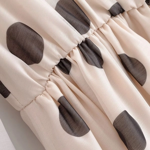 Vue détaillée du tissu crème à pois noirs avec coutures élastiques froncées à la taille