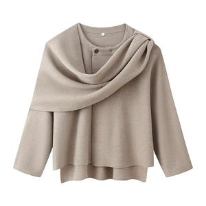 Detail of oatmeal knit sweater featuring a unique scarf-style collar and button accent