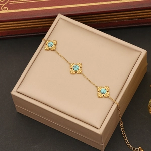 Vintage stainless steel gold flower bracelet with turquoise stone inlays on jewelry box