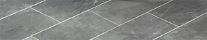 Close-up of deep grey rectangular laundry tub with natural stone texture finish