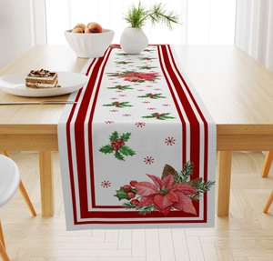 Close-up of linen Christmas table runner with poinsettia, holly, and pine branch patterns