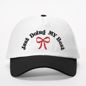 Just Doing My Best embroidered black and white contrast baseball cap with red bow detail