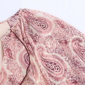 Macro view of paisley print dress detail with fine stitching on shoulder and neckline