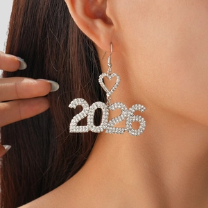 Detail of silver heart-shaped earring with 2026 rhinestones on model's ear