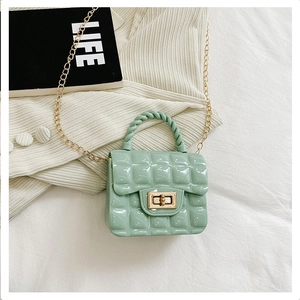 Close-up of mint green quilted jelly bag with gold chain strap and twist handle