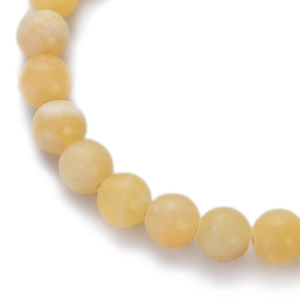 Macro shot of smooth natural yellow chalcedony agate beads showing stone texture
