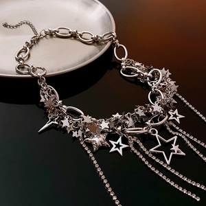 Close-up of silver layered necklace featuring rhinestone star pendants and tassel details
