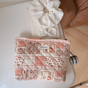 Detailed shot of floral quilted cotton makeup bag with rabbit prints and simple wish label