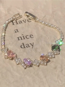 Detail view of oval multicolor gemstones and sparkling cubic zirconia on gold bracelet