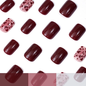 Short square press-on nails with burgundy leopard print and red heart glitter designs