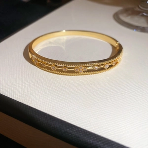 Detailed macro view of 18k gold plated bangle with zircon flowers and beaded edges