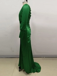 Detail of emerald green satin evening dress featuring pleated long sleeves and waist design