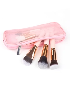 Dettaglio della borsa trucco in rete rosa e pennelli professionali con ghiere oro rosa