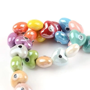 Macro view of colorful heart-shaped ceramic evil eye beads for DIY jewelry making