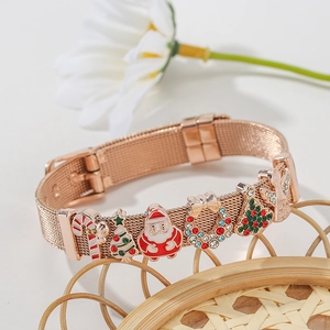 Macro shot of rose gold stainless steel mesh bracelet with colorful Christmas charms