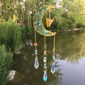 Detail of moon-shaped garden suncatcher with natural stones, butterfly and crystal prism