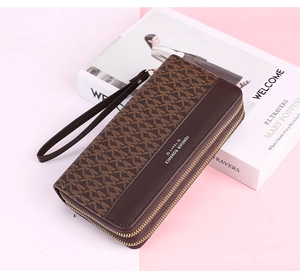 Detail of long wallet showing dual zippers, brown monogram print and leather texture