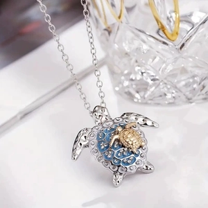 Two-tone sea turtle necklace with blue enamel and crystal inlay on a silver chain