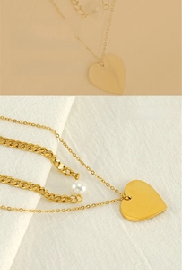 Detail of double-layer heart pendant necklace with gold chain and freshwater pearl accent