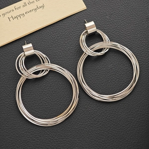 Minimalist silver multi-layered hoop earrings with polished metal finish on leather