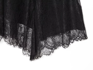 Detailed close-up of intricate black floral lace fabric with delicate eyelash trim