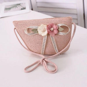 Detail of pink straw bag showing woven texture, dual-color floral accents and cotton strap