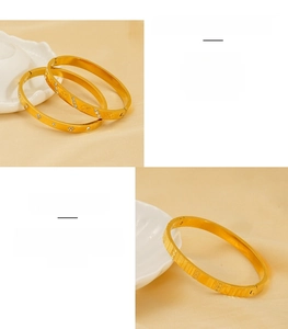 Detailed close-up of 18k gold-plated stainless steel bangles with star patterns and engravings