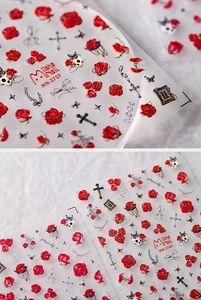 Detailed macro of matte Gothic nail stickers featuring red roses and silver crosses