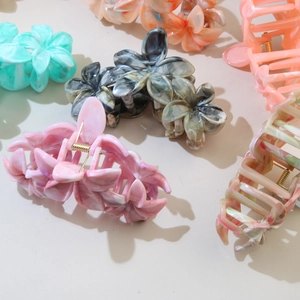 Close-up of assorted colorful floral hair claws in pink blue and orange matte finish