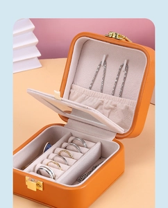 Detail view of the bright orange jewelry box with ring slots and white velvet interior