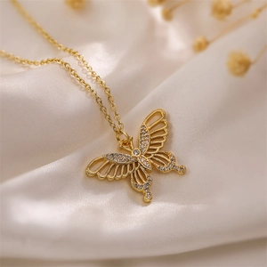 Macro detail of golden butterfly necklace with white zircon stones and hollow wings