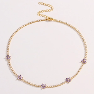 Elegant gold flower necklace with purple zircon stones on a white background