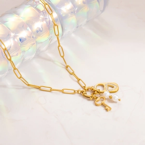 Close-up of 18k gold plated necklace with heart lock, key pendant and white pearls