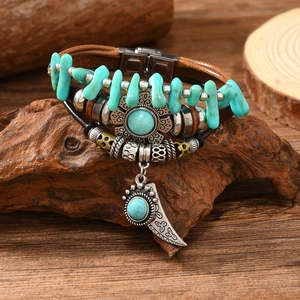 Detail of vintage bohemian leather bracelet featuring turquoise beads and crescent moon charm