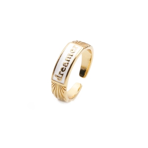 Close-up of gold-plated ring with white enamel and dreamer inscription detail
