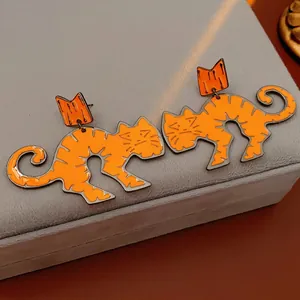 Cute minimalist orange cat-shaped crown stud earrings with silver needle on gray velvet box